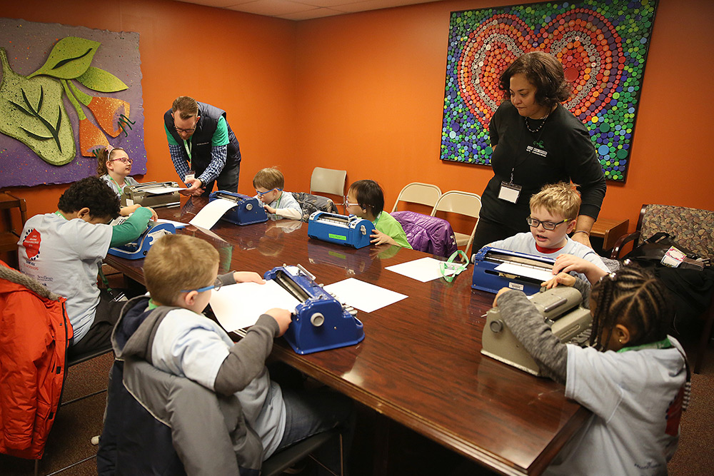 Young students participate in the Ohio Regional Braille Challenge braille explorers activities with volunteers.