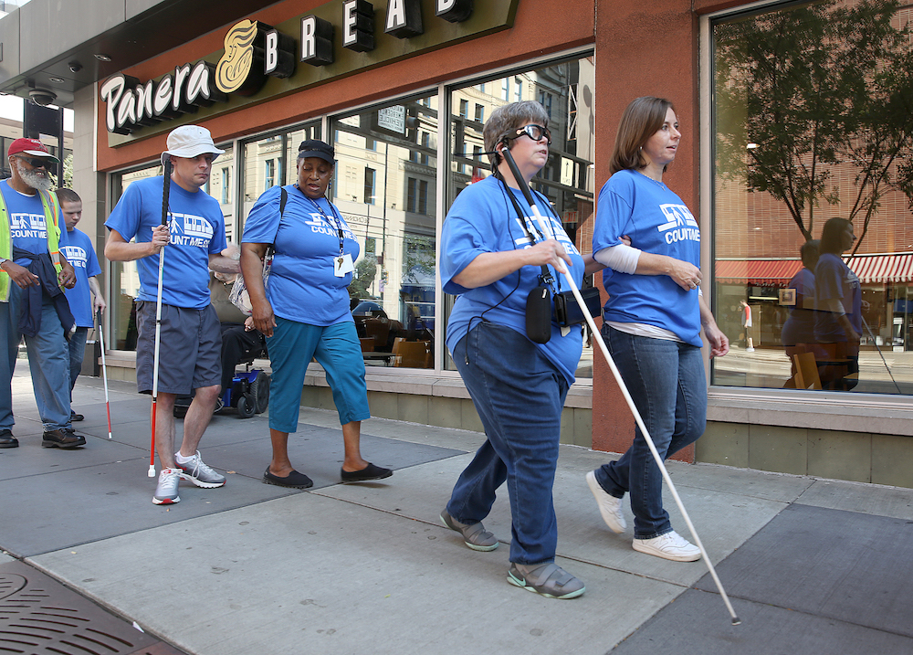 Clovernook Center for the Blind & Visually Impaired employees, both sighted and BVI, use white canes to navigate Cincinnati streets to celebrate White Cane Awareness Day.