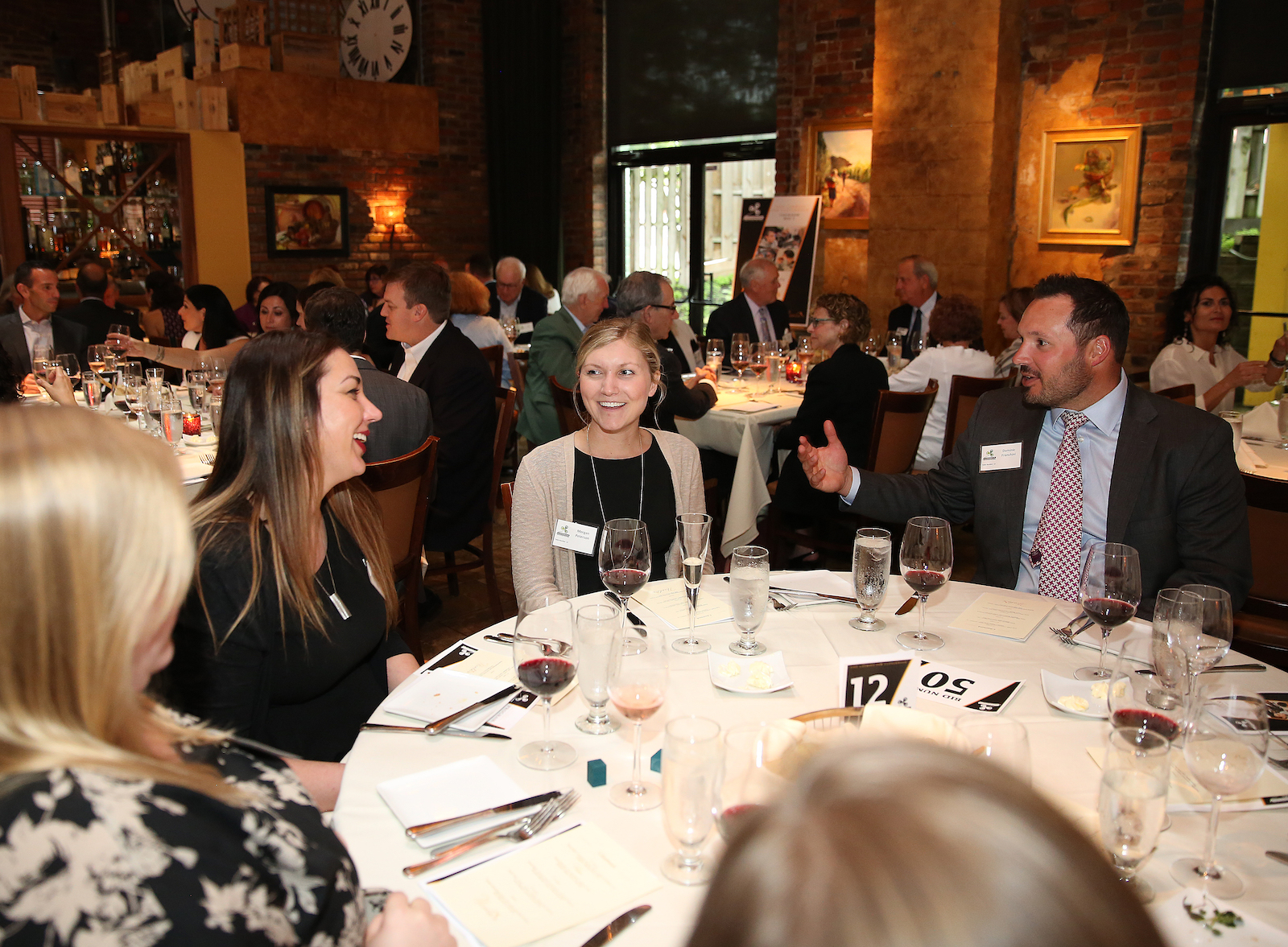 Clovernook Center supporters enjoy a five course meal together at a large table.