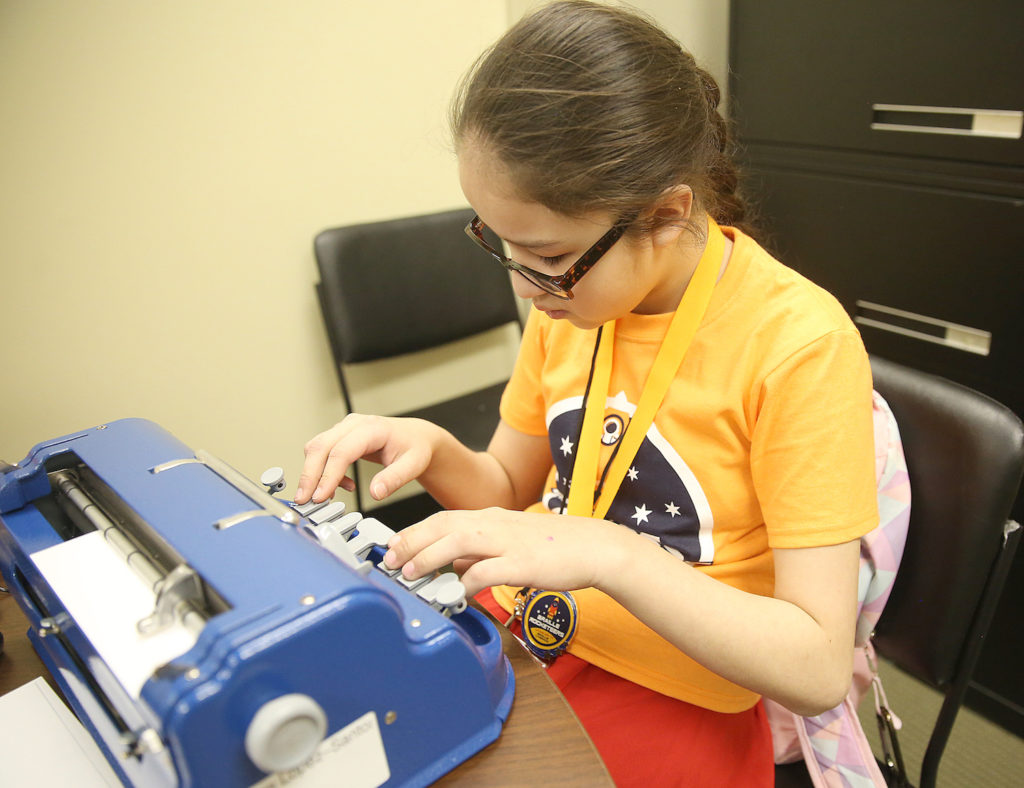 A student participates in a challenge activity with her brailler at the Ohio Regional Braille Challenge.
