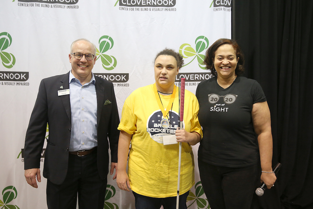 Camryn receives the Clovernook Prize for the highest proofreading score from Clovernook Center president Chris Faust and board member Susan Baillely.