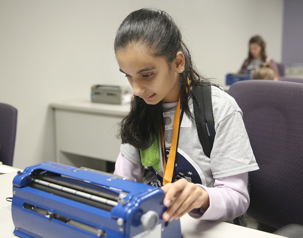 Girl typing on a brailler